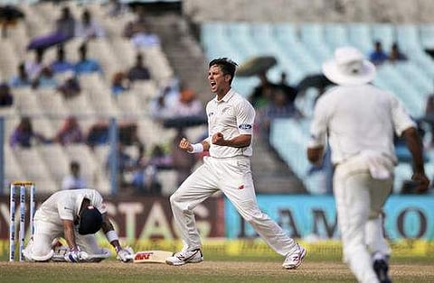 New Zealand's Trent Boult, right, celebrates after taking the wicket of India's Virat Kohli, left, on the third day of the second cricket test match, in Kolkata. (AP)