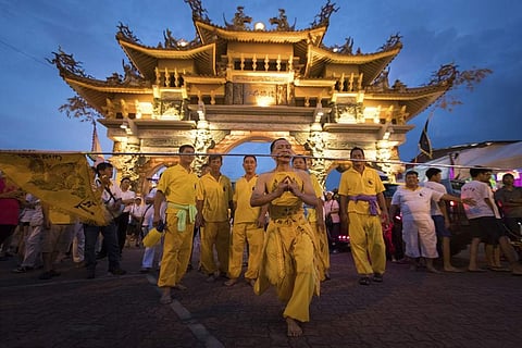 A devotee at the Chinese Shrine of Nine Emperor Gods with a 4.5 meter (9 feet) spear through his cheeks, starts the procession during the 5th day celebration of Nine Emperor God Festival. (Photo | AP)