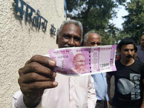 A man shows the new currency note in Kozhikode. ( Sanesh A. | EPS)