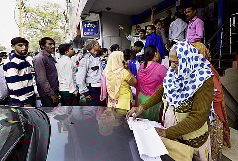 People queue outside Bank of India to exchange their old Rs 500 and 1000 notes in New Delhi on Friday. | PTI