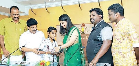 Assistant district collector Renu Raj handing over Rs 50,000 to 15-year-old Abhinava