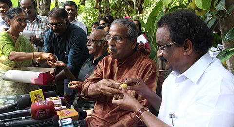 Writer C Radhakrishnan giving sweets to minister A K Balan during the anouncement of Ezhuthachan Award at his house in Kochi on Tuesday | Melton Antony