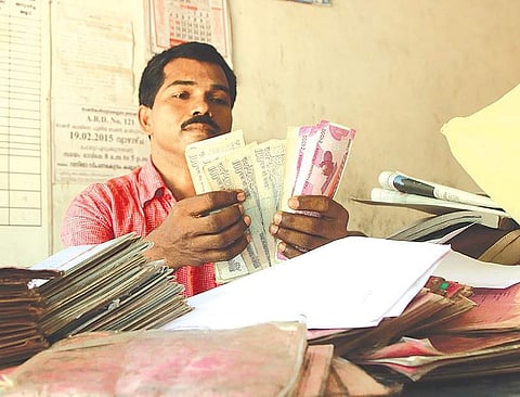 Ration dealer Natarajan, who accepts scrapped notes from his Adivasi customers, counts cash before depositing them in his bank account| Albin Mathew