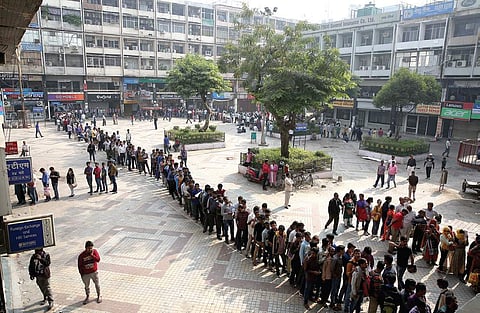 People queue up outside a bank in Delhi