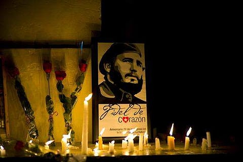 An image of the late Cuban leader Fidel Castro, surrounded by candles and roses, leans against a wall of the university in Cuba.(Photo | AP)