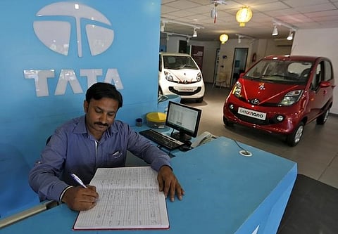 An employee writes on a register inside the Tata Motors car showroom in Ahmedabad | Reuters