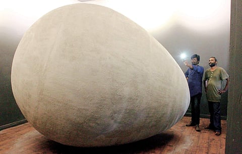 A visitor taking a photograph of the installation titled Garbh, a giant egg-shaped sculpture put on exhibition at the Kochi-Muziris Biennale  on Tuesday |  Albin Mathew
