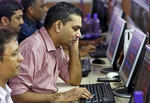 Brokers trade at their computer terminals at a stock brokerage firm in Mumbai. (File | Reuters)