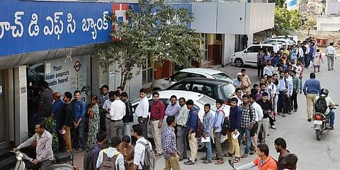People stand in a serpentine queue outside a bank after demonetisation.