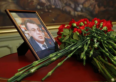 Flowers lay next to a portrait in memory of Russian Ambassador to Turkey Andrei Karlov, who was fatally shot by a Turkish policeman Monday in a gathering in Ankara, Turkey. | AP