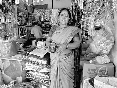 A member of Zilla Mahila Samakhya showing a non-functional e-PoS machine at the e-mandi set up at Srikakulam rythu bazaar on Saturday | Express