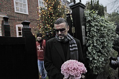 In this Friday, Dec. 23, 2011 file photo, British singer George Michael leaves his house in north London, after recovering from a life-threatening bout with pneumonia that kept him in a Vienna hospital for a month. | AP