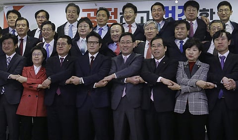 A group of lawmakers of the ruling Saenuri Party joins their hands during a press conference to announce to leave the party at the National Assembly in Seoul, South Korea, Tuesday, Dec. 27, 2016. | AP