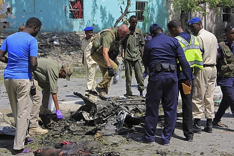 Somali soldiers stand over the wreckage of a car bomb in Mogadishu Somalia, Thursday, Dec. 15, 2016. | AP