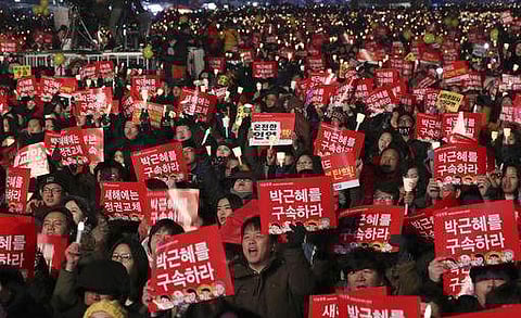 Protesters shout slogans as they hold signs and candles during a rally demanding the resignation of South Korean President Park Geun-hye in Seoul. (Photo | AP)