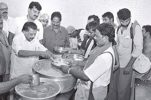 Travancore Devaswom Board president Prayar Gopalakrishnan distributing free food to pilgrims at the Pampa free food distribution centre on Sunday | SHAJI VETTIPURAM