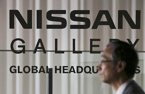 A man walks in front of the logo of Nissan Motor Co. at the gallery at its global headquarters in Yokohama, near Tokyo Monday, Nov. 7, 2016.| AP