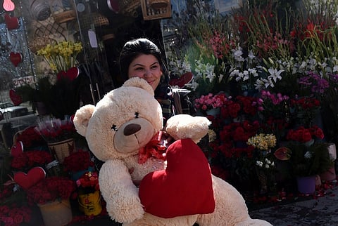 Afghan resident Rahat Fakhri, 21, carries a teddy bear purchased as a gift for her fiance to celebrate Valentine's Day in the Shar-e-Naw area of Kabul. (AFP)