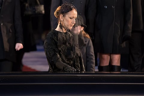 Céline Dion kisses the casket of of her late husband René Angélil outside Montréal's Notre-Dame Basilica following his funeral. |AFP