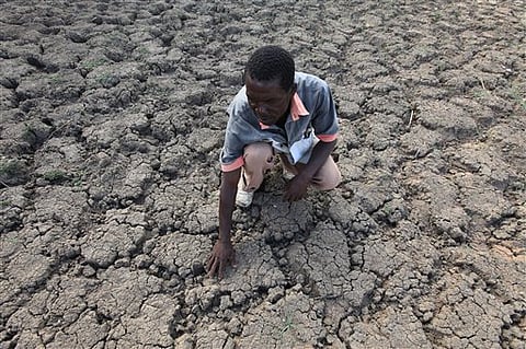In this photo taken Sunday Jan. 29, 2016, Last Zimaniwa feels the broken ground at a spot which is usually a reliable water source that has dried up due to lack of rains in the village of Chivi , Zimbabwe. 