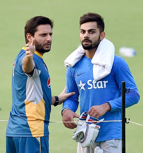 Kolkata Pakistan's captain Shahid Afridi with Virat Kohli during their training session at the Eden Gardens in Kolkata. |PTI