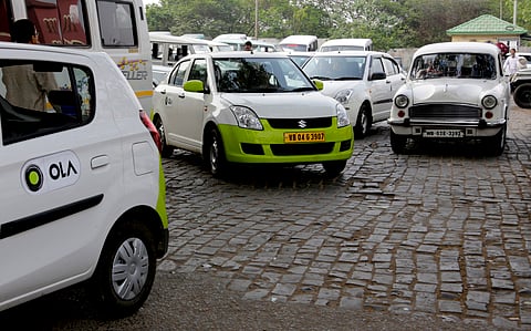 In this March 29, 2016 photo, Ola cabs, left, waiting for customers are parked next to other cars in Kolkata, India. Aiming to wrest control of India’s booming taxi market, two cab-hailing smartphone apps, Uber and Ola, are promising hundreds of millions 