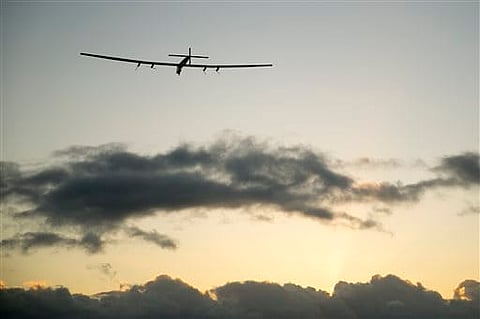 The Solar Impulse 2 solar plane flies into the sunrise out of Kalaeloa Airport in Kapolei, Hawaii. |AP