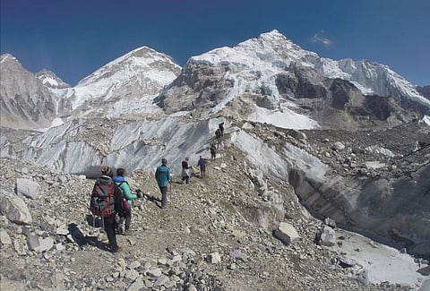  In this Monday, Feb. 22, 2016 file photo, international trekkers pass through a glacier at the Mount Everest base camp, Nepal. A Nepal official says some 30 climbers have gotten frostbite or become sick on Mount Everest, in addition to two who died in re