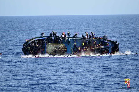 People try to jump in the water right before their boat overturns off the Libyan coast. 