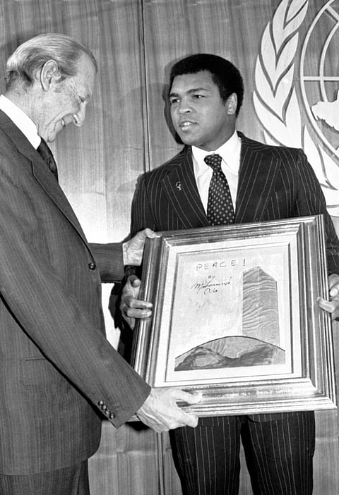 In this Jan. 30, 1979, file photo, U.N. Secretary-General Kurt Waldheim, left, admires "Painting For Peace" displayed by world heavyweight champ Muhammad Ali at the United Nations. | AP