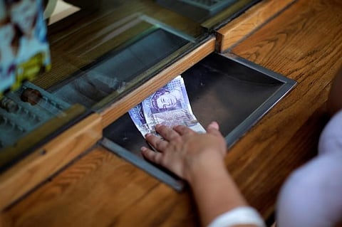 A woman exchanges English Pound notes for Euros notes at a money exchange office in the British overseas territory of Gibraltar, historically claimed by Spain. (Reuters)