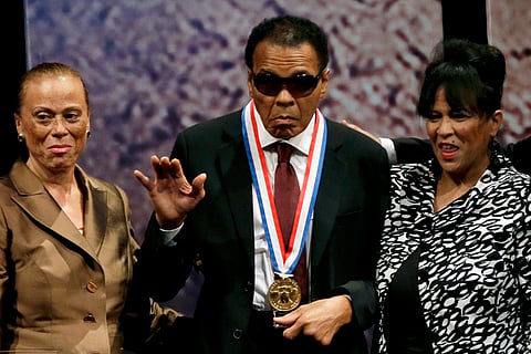 FILE - In this Sept. 13, 2012, file photo, retired boxing champion Muhammad Ali, center, waves alongside his wife Lonnie Ali, left, and his sister-in-law Marilyn Williams, right, after receiving the Liberty Medal during a ceremony at the National Constitu