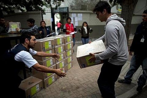 Electoral workers carry voting boxes to a polling station in Lima, Peru ahead of  a tight June 5th runoff between Keiko Fujimori, the daughter of jailed former President Alberto Fujimori, and former World Bank economist Pedro Kuczynski (AP)