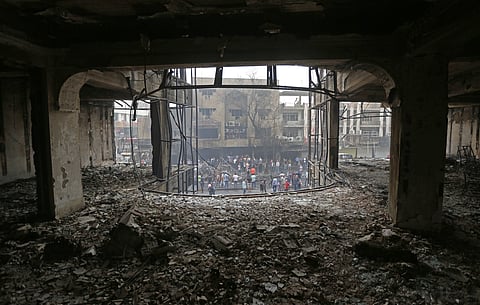 Iraqi security forces and civilians gather at the site of a car bomb at a commercial area in the Karada neighborhood, Baghdad, Iraq, Sunday, July 3, 2016. Dozens of people have been killed and more than 100 wounded in two separate bomb attacks in the Iraq