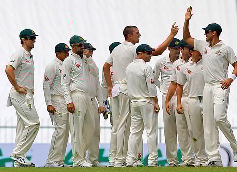 Australian teammates congratulate their bowler Josh Hazlewood, center, for taking the wicket of Sri Lanka's Kusal Mendis, unseen, on day one of the first test cricket match between Sri Lanka and Australia in Pallekele, Sri Lanka, Tuesday, July 26, 2016.