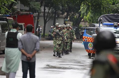 Bangladeshi soldiers come out of an area housing a restaurant popular with foreigners after heavily armed militants attacked it on Friday night and took dozens of hostages, in a diplomatic zone of the Bangladeshi capital Dhaka. (AP)