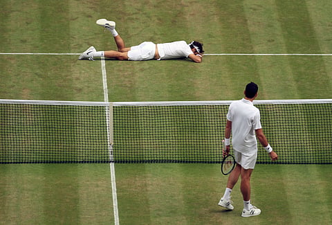Roger Federer of Switzerland, top, falls over during his men's semifinal singles match against Milos Raonic of Canada on day twelve of the Wimbledon Tennis Championships in London, Friday, July 8, 2016. | AP