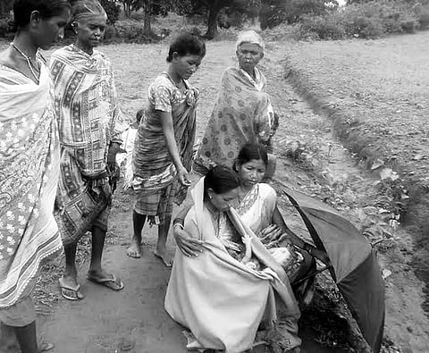 Relatives surround Situmai as she delivers on road. | EPS