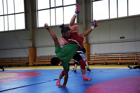 This picture taken on July 1, 2016 shows 26-year-old Olympian Soronzonboldyn Battsetseg (top) wrestling during a training session in Bayanchandmani, west of Ulan Bator. | AFP
