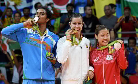 Silver medalist V. Sindhu Pusarla of India gold medalist Carolina Marin of Spain and bronze medalist Nozomi Okuhara of Japan celebrate during the medal ceremony after the Women's Singles Badminton competition on Day 14 of the Rio 2016 Olympic Games at Ri