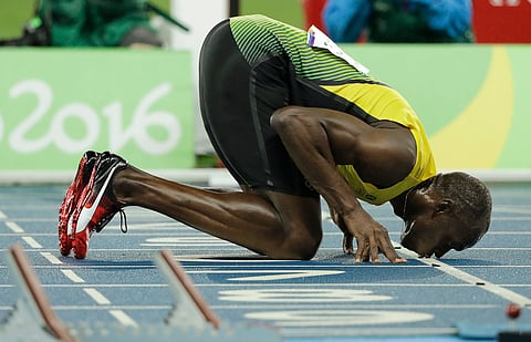 Usain Bolt from Jamaica kisses the track after winning the men's 200-meter final during the athletics competitions of the 2016 Summer Olympics at the Olympic stadium in Rio de Janeiro, Brazil, Thursday, Aug. 18, 2016. | AP