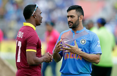 West Indies' Dwayne Bravo, left, and India's MS Dhoni, right, talk during a rain delay at the second Twenty20 international cricket match. | AP
