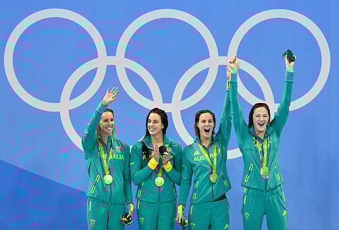 Australia's Emma McKeon, Brittany Elmslie, Cate Campbell and Bronte Campbell, from left, celebrate their gold medals after winning the women's 4x100-meter freestyle relay final setting a new world record during the swimming competitions at the 2016 Summ