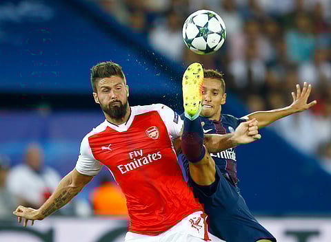 PSG's Marquinhos, right, challenges for the ball with Arsenal's Olivier Giroud during the Champions League group A soccer match group between Paris Saint Germain and Arsenal at the Parc des Princes stadium in Paris, Tuesday, Sept. 13, 2016. | AP