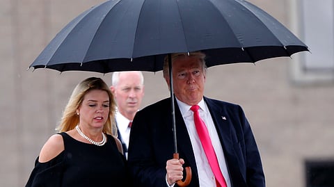 In this August 24, 2016 file photo, Donald Trump walks in the rain with Pam Bondi