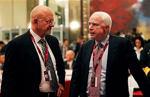 (File Photo | AP) U.S. Senator John McCain, right, speaks with Director of National Intelligence James Clapper, left, at the IISS Summit in Singapore