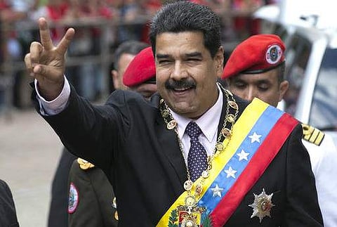 Venezuela's President Nicolas Maduro flashes a victory sign to supporters as he arrives to the Supreme Court to deliver his annual state of the nation report in Caracas. | AP