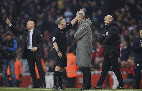 Referee Jonathan Moss, centre left, sends Arsenal manager Arsene Wenger, centre right, to the stands during their game against Burnley, during their EPL match at The Emirates Stadium in London. | AP