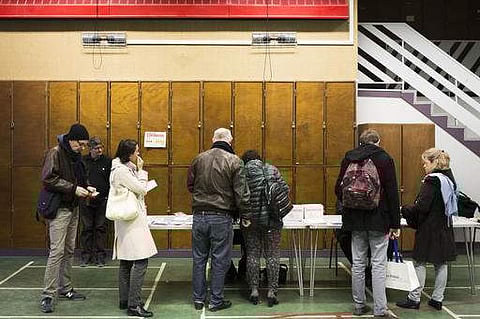 People wait in a line to vote at a polling station during the first round of the French left's presidential primaries, ahead of the 2017 presidential election in Paris, Sunday, Jan. 22, 2017. Seven candidates are running in the first round of France's lef