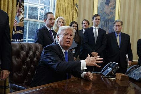 President Donald Trump talks with reporters in the Oval Office of the White House on January 24 before signing an executive order on the Keystone XL pipeline. | AP